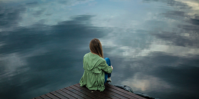 Woman Sitting on Lake Dock